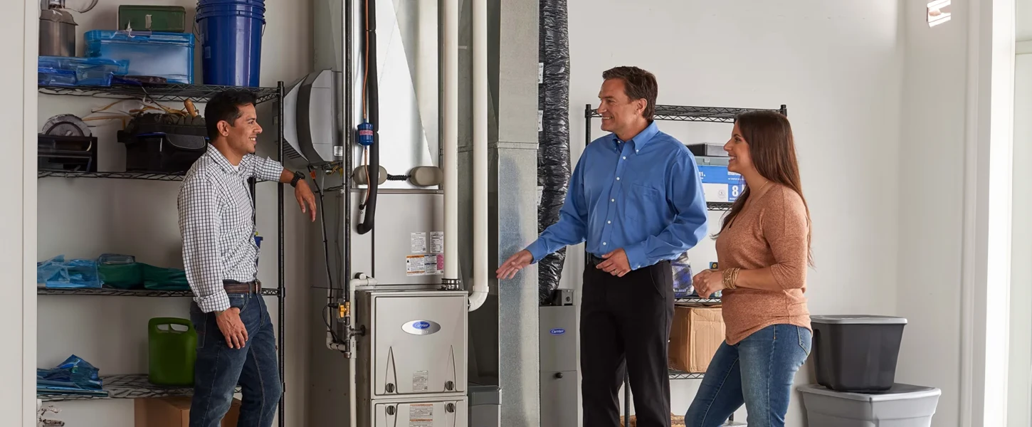 a group of people standing in a room talking about heating repair